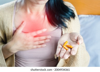 Woman Taking Turmeric Pill, Or Curcumin Herb Medicine For GERD, Treatment For Heartburn From Acid Reflux Disease