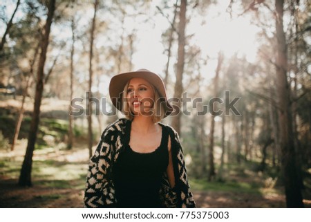 Similar – Image, Stock Photo Blonde woman with hat taking a walk in the forest at sunset with the sun in the background.