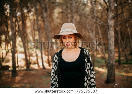 Similar – Image, Stock Photo Blonde woman with hat taking a walk in the forest at sunset with the sun in the background.