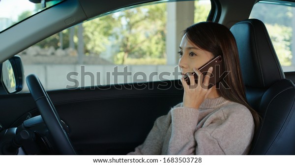 Woman talk to cellphone\
and drive a car