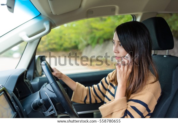 Woman talk to cellphone\
and driving car