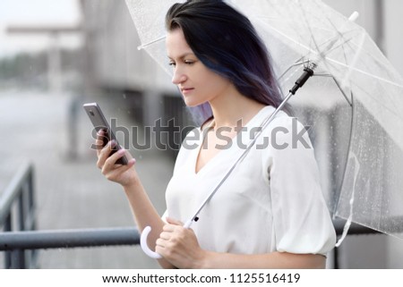 Woman talk to cellphone with umbrella