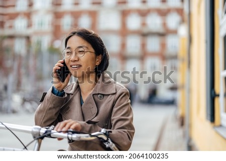 Woman talking about business problem on smart phone, on the street of European city.