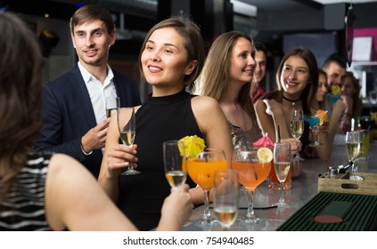 Woman Is Talking With Colleague At Corporate Event In Bar. 