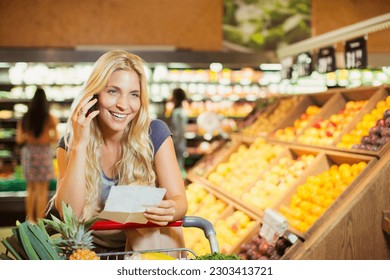 Woman talking on cell phone in grocery store - Powered by Shutterstock