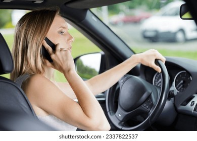 woman talking on cellphone while driving - Shutterstock ID 2337822537