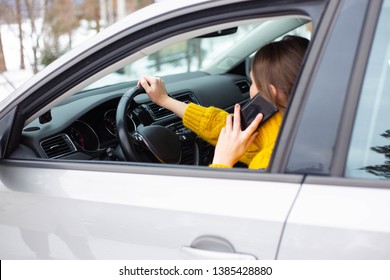 Woman is talking on her phone while driving a car