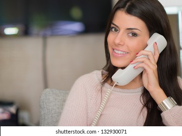 Woman Talking On Landline Telephone, Indoors