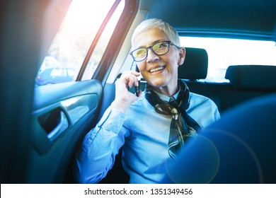 Woman talking on the phone while traveling by car.