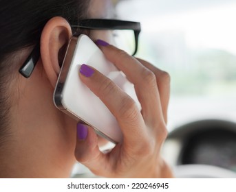 Woman talking on the phone while driving a car - Powered by Shutterstock