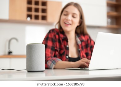 Woman talking to smart speaker. Intelligent assistant in smart home system. - Powered by Shutterstock