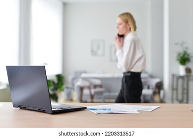 Woman talks on the phone and walks around her workplace