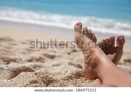 Woman tanned legs on sand beach. Travel concept. Happy feet in tropical paradise
