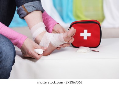 Woman taping her foot with bandage - Shutterstock ID 271367066