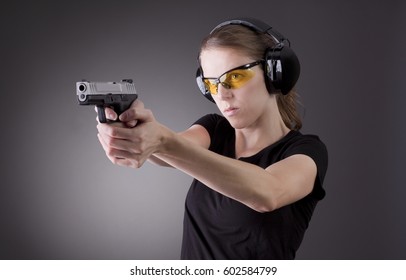 A woman target practicing with a handgun for self defense.