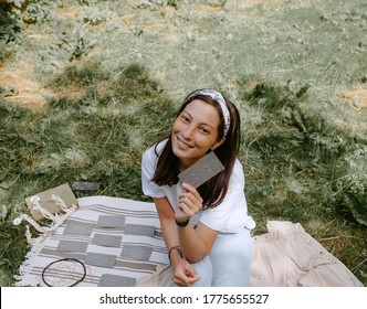 Woman With Tarot Cards On A Picnic