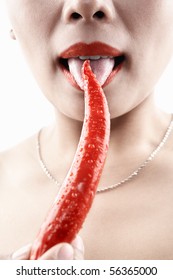 Woman Tasting Big Red Chili With Her Tounge