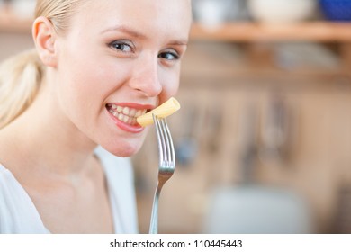 Woman Tasting Cooked Macaroni In The Kitchen, Preparing Mac And Cheese