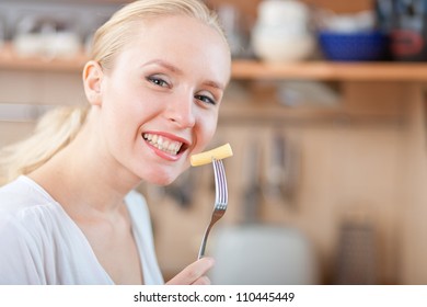 Woman Tasting Cooked Macaroni In The Kitchen, Preparing Mac And Cheese