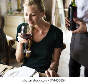 Woman Tasting Red Wine In A Classy Restaurant