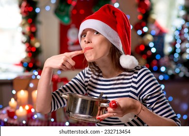 Woman Tasting Something Licking Her Finger On Christmas. Cooking On Christmas