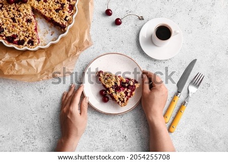 Woman with tasty cherry pie and cup of coffee on light background