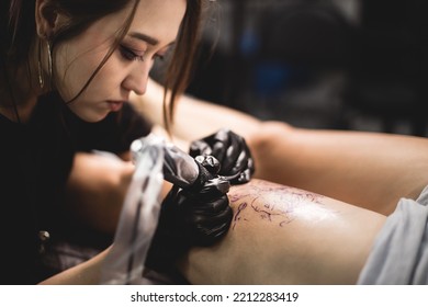 Woman Tattoo Artist Doing Tattoo In Studio, Making Tattoo On Body. Closeup