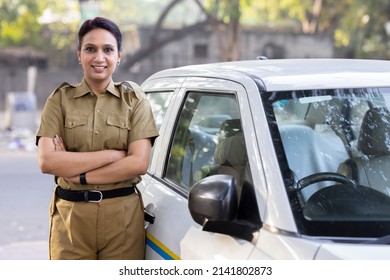 Woman Taxi Driver With Arms Crossed By Her Car
