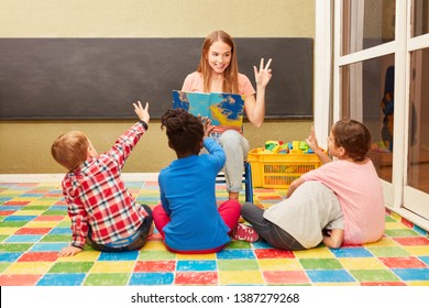 Woman As A Teacher And Children Have Fun Together While Reading Aloud In Kindergarten Or Daycare