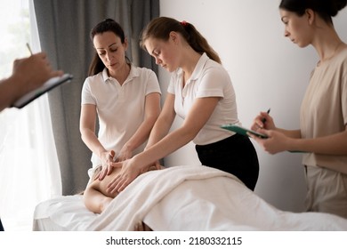 Woman teacher helping students become a masseuse, wellness massage training - Powered by Shutterstock