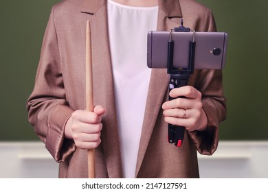 Woman Teacher With Phone For Online Lesson On School Blackboard In The Classroom