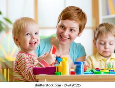 Woman Teaches Children Handcraft At Kindergarten Or Playschool