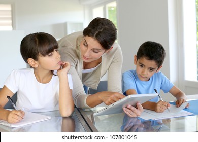 Woman teaching class to school children with digital tablet - Powered by Shutterstock