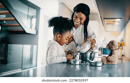 Woman teaching her daughter how to mix flour for baking. Happy mom making a cake with her daughter in the kitchen. Mother passing a family recipe to her child. - Powered by Shutterstock