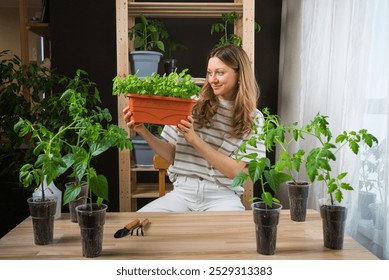 Woman tending indoor garden with basil and tomato plants, home gardening with potted herbs and vegetables, sustainable living concept  - Powered by Shutterstock