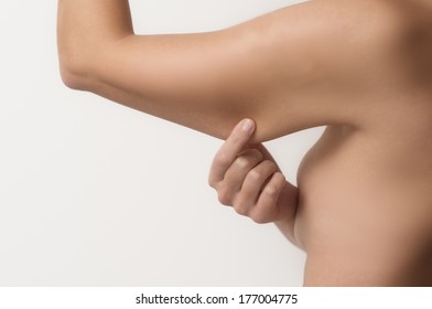 Woman Testing The Flabby Muscle Under Her Arm Pulling It Down With Her Hand As She Checks For Muscle Tone Or Weight Gain