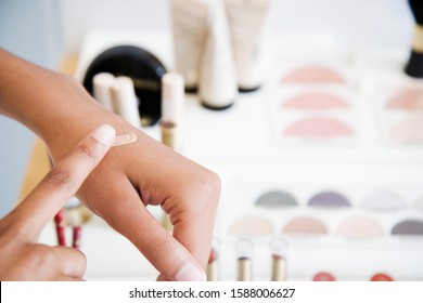 Woman Testing Foundation Cream On Her Hand At The Cosmetics Counter