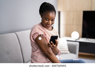 Woman Testing Glucose Level With Continuous Glucose Monitor On Mobile Phone