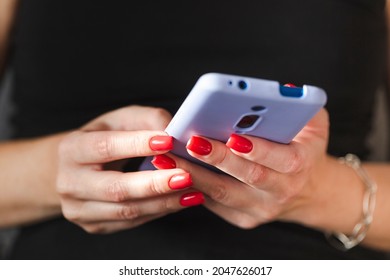 Woman Texting Using Mobile Phone, Hands With Red Nail Polish Manicure In Frame. Online Shopping.