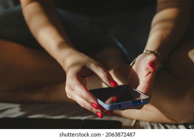 Woman Texting Using Mobile Phone, Hands With Red Nail Polish Manicure In Frame. Online Shopping.