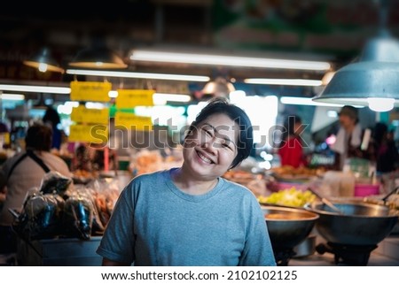 Woman at Thai street food with curry and rice shop in market