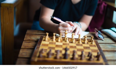 Woman is thinking about chess strategy.