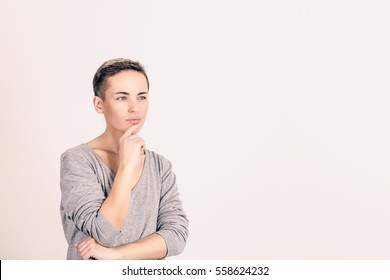 Woman thinking. Portrait close up of happy beautiful young woman thinking looking away, up isolated grey wall background with copy space. Human face expressions, emotions feelings, body language