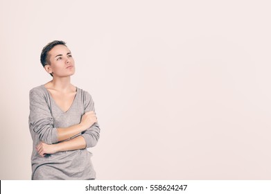 Woman thinking. Portrait close up of happy beautiful young woman thinking looking away, up isolated grey wall background with copy space. Human face expressions, emotions feelings, body language - Powered by Shutterstock