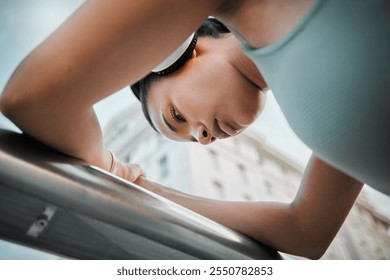 Woman, thinking and tired athlete in city, low angle and outdoor for streaming music in training. Female person, exhausted runner and contemplating in town, morning fatigue and headphones for sound - Powered by Shutterstock