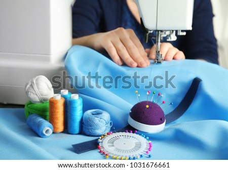 Woman threading modern sewing machine, closeup
