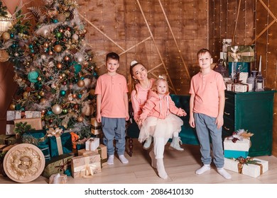 a woman and three children in single clothes sit on the couch for Christmas - Powered by Shutterstock