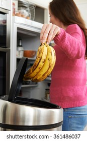 Woman Throwing Away Out Of Date Food In Refrigerator