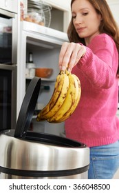 Woman Throwing Away Out Of Date Food In Refrigerator