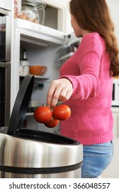 Woman Throwing Away Out Of Date Food In Refrigerator